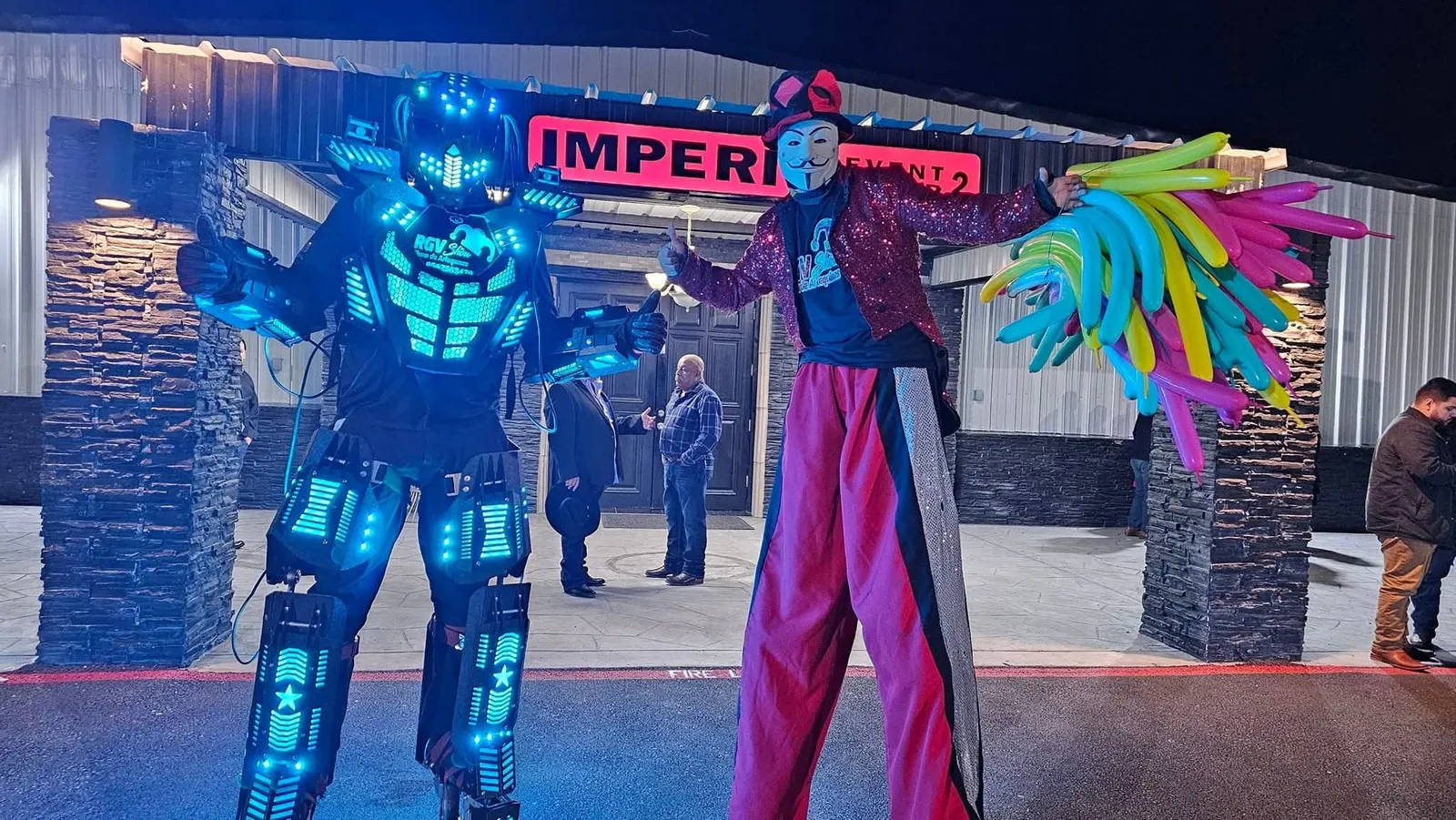 Robot LED y arlequín en zancos